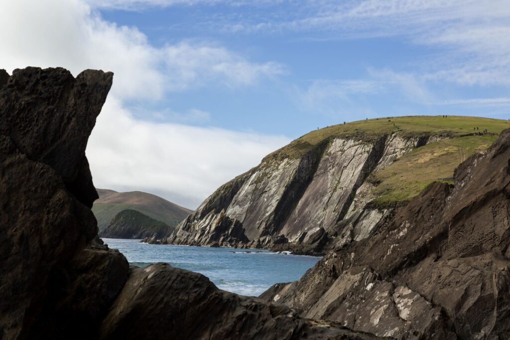 Green headlands and steep sea cliffs along the Dingle Peninsula in Ireland.