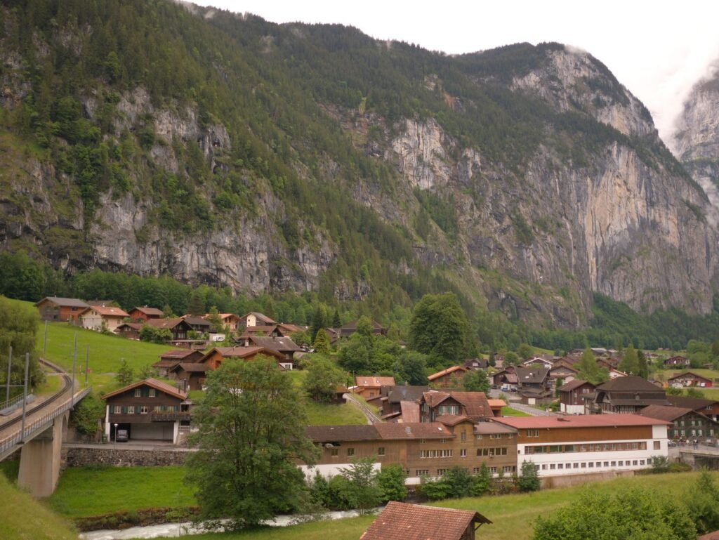 Lauterbrunnen village and chalets beneath steep green mountains in the Swiss Alps.