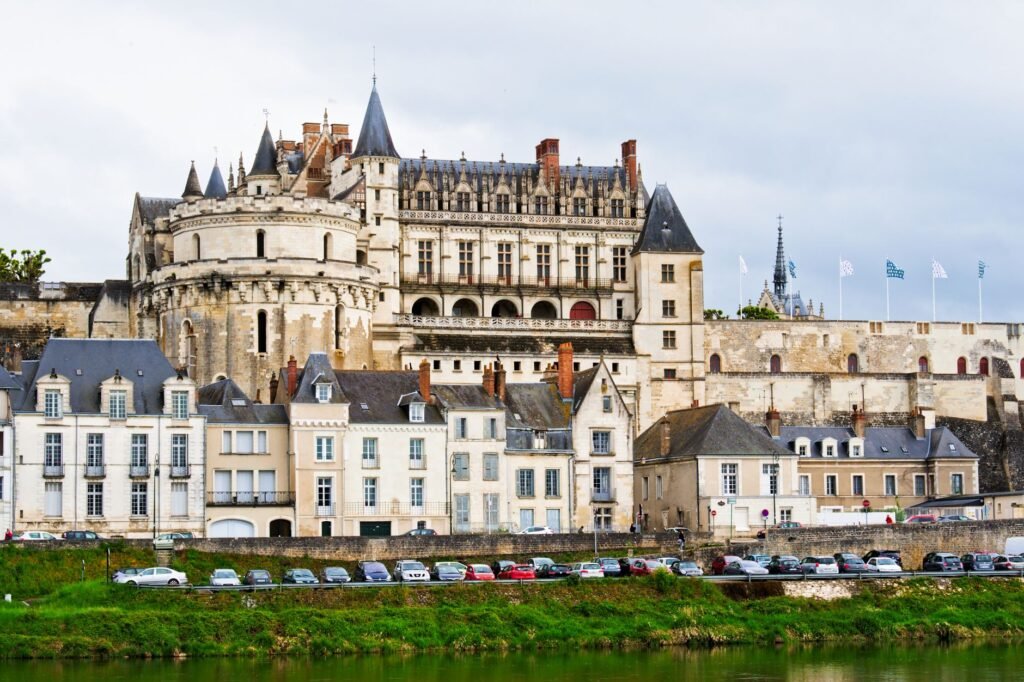 Royal Château of Amboise rising above stone buildings beside the Loire River in France.