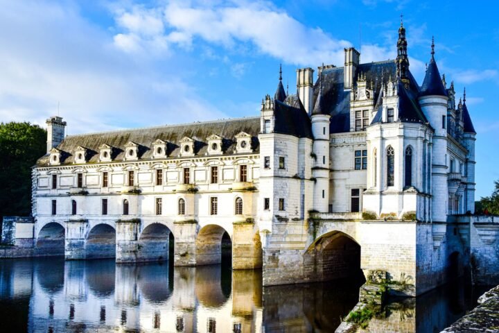 Château de Chenonceau spanning the River Cher beneath a pale sky in France.