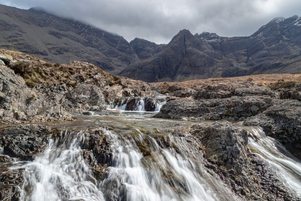 Rocky cascades of the Fairy Pools flowing below dark Cuillin mountains on the Isle of Skye.