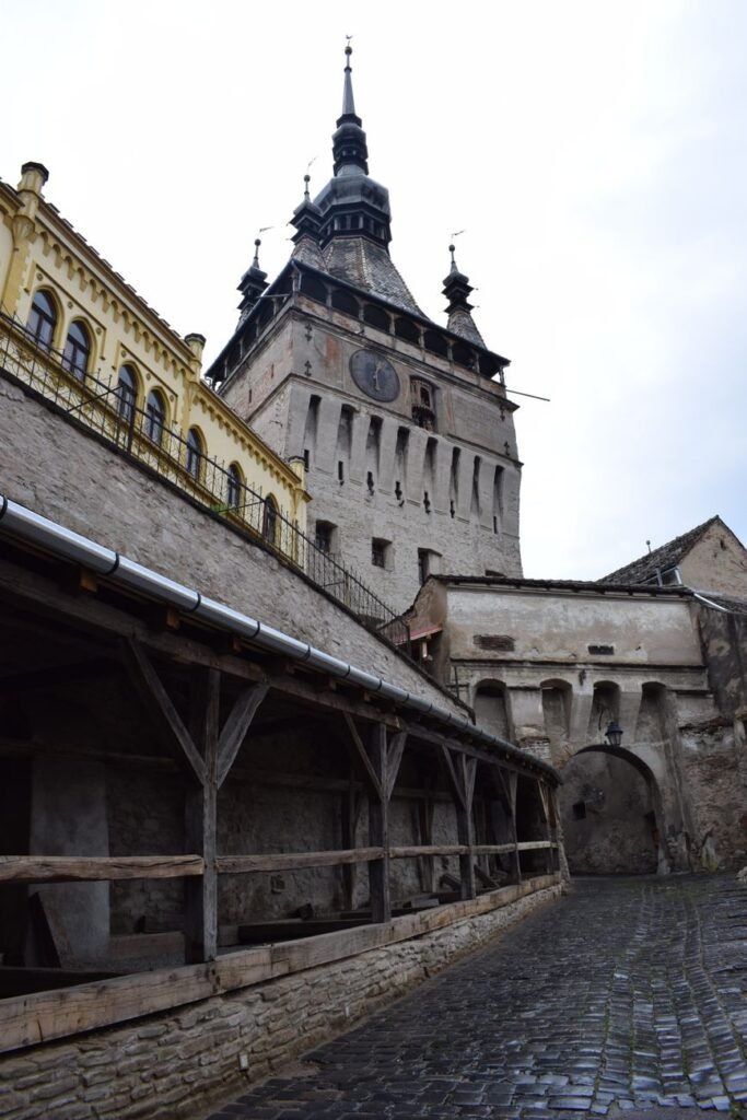 The historic Clock Tower above tiled rooftops in Sighișoara, Romania.