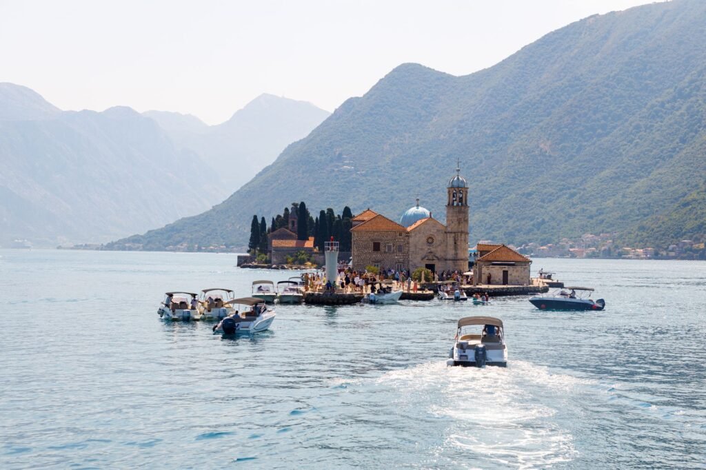 Boats approaching the church island of Our Lady of the Rocks in Kotor Bay, Montenegro.